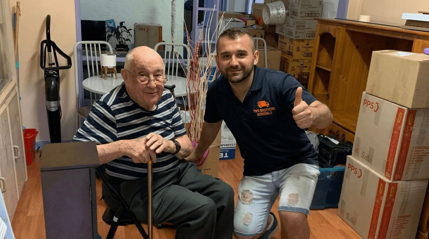 Two Brothers removalist giving a thumbs up alongside an elderly customer in his new home