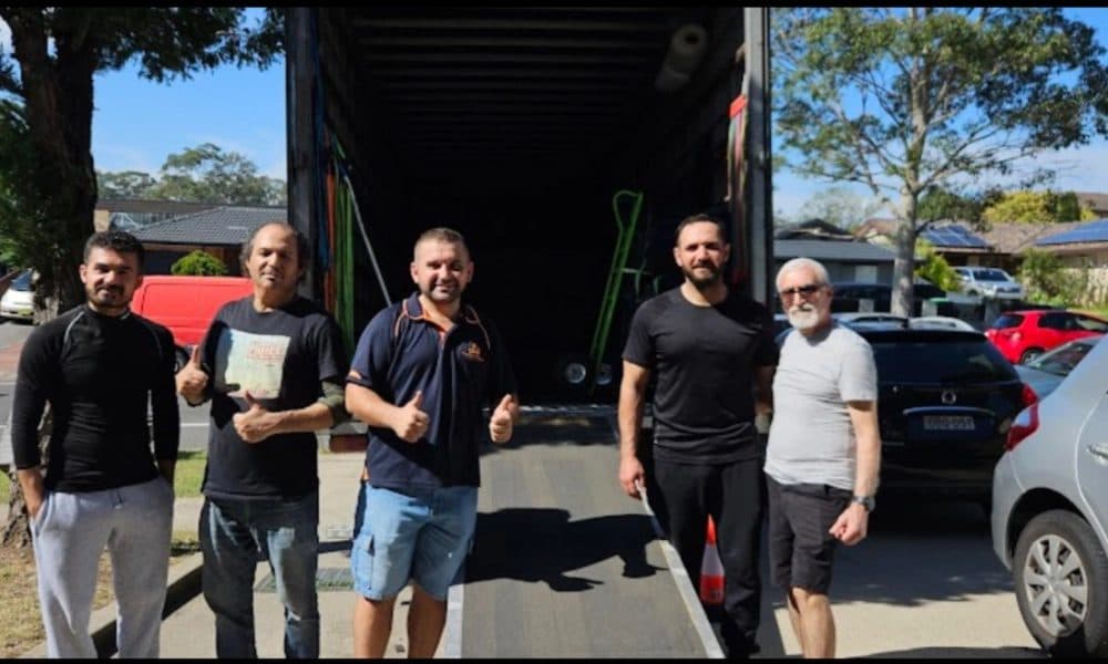 Two Brothers removalist and satisfied customers giving thumbs up at the truck ramp