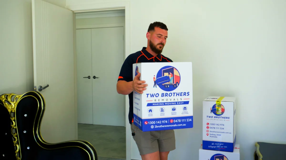 Crew carrying blanket-wrapped furniture out of a Sydney home